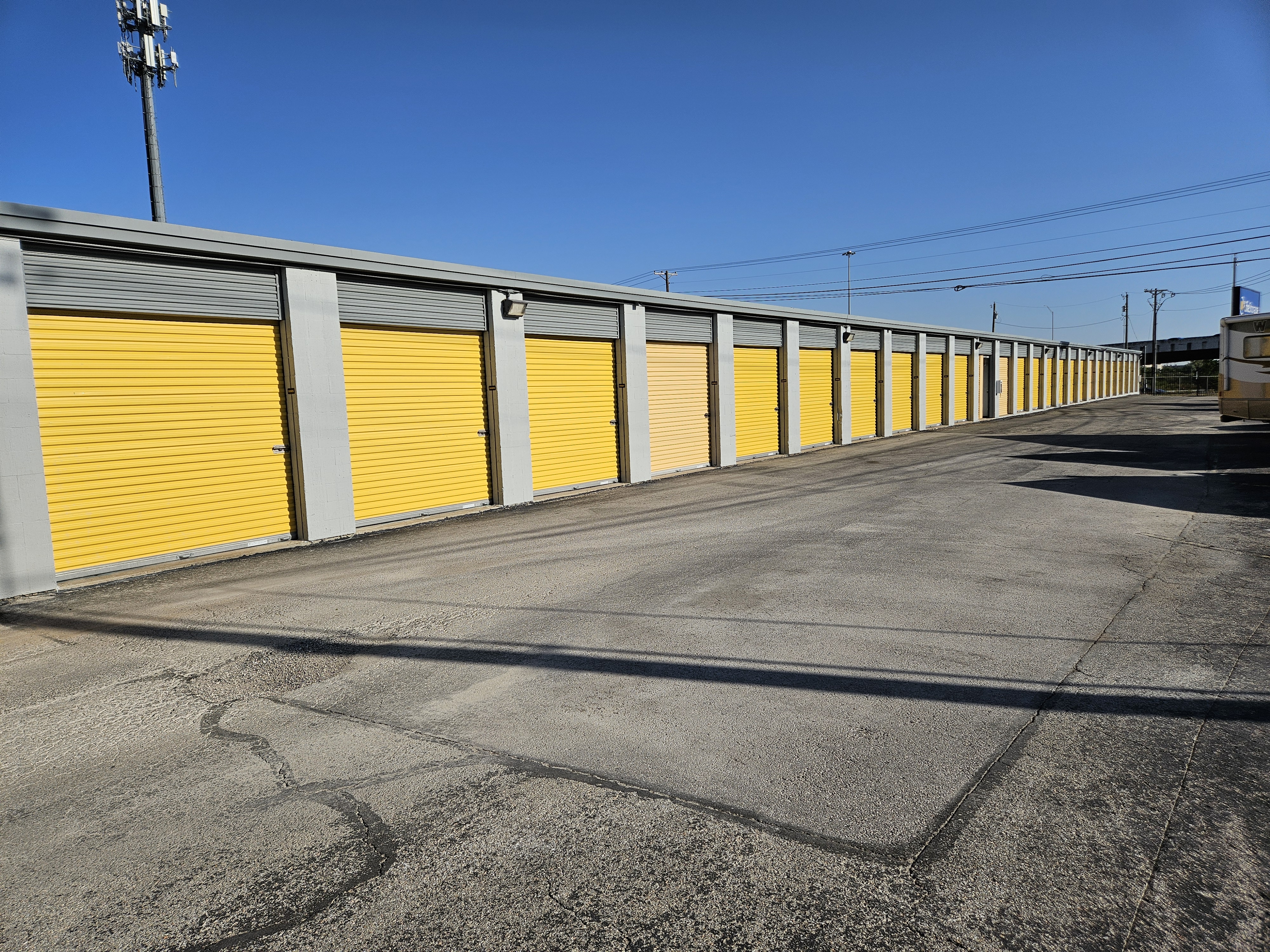 Row of secure yellow drive-up storage units at Round Rock Secure Storage near Hutto, TX.